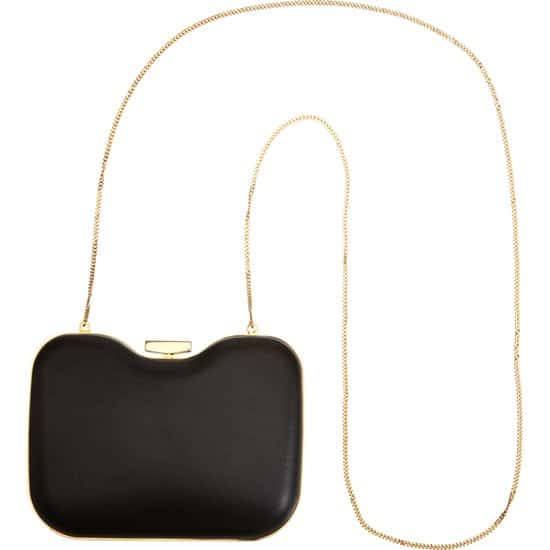 A curvy Italian clutch with two-tone metallic trim serves as a fashionable study in contrast, with matte black leather wrapping one side and a cool grey patent on the other
