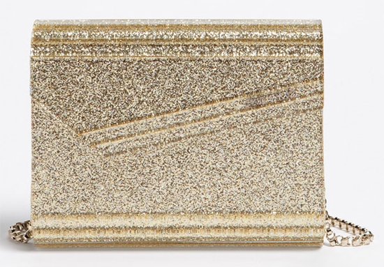 An arresting clutch is fashioned from glossy acrylic infused with glitter and subtly branded at the angular envelope-flap closure