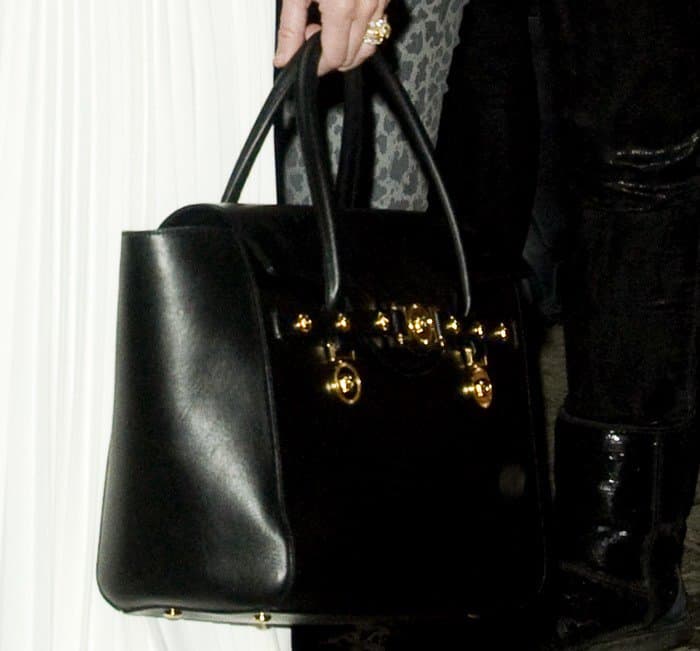 Miley Cyrus totes a black Versace Large Signature flap handle bag
