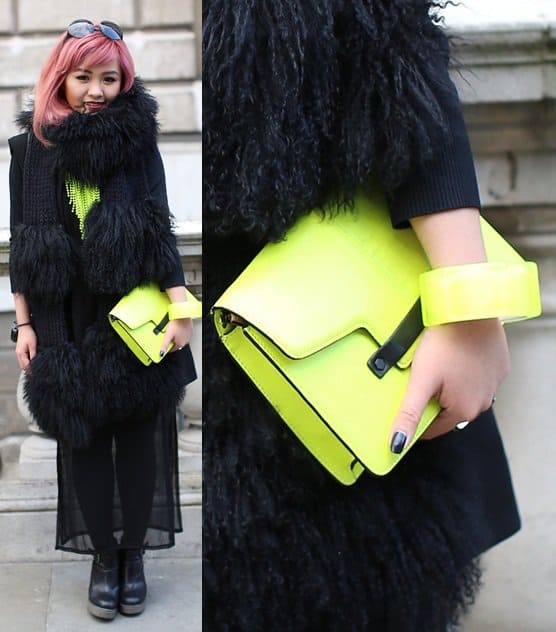 Pink-haired model carrying a neon yellow bag