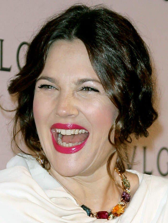 Drew Barrymore shows off her teeth at the celebration of Elizabeth Taylor's collection of BVLGARI jewelry