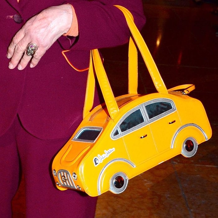Heidi Hetzer carrying a yellow car purse