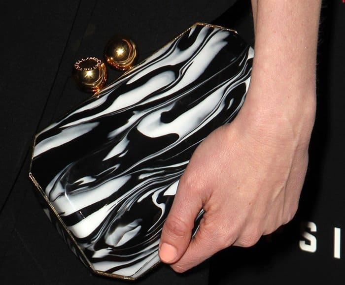 Kirsten Dunst holding a black and white marble Stella McCartney clutch