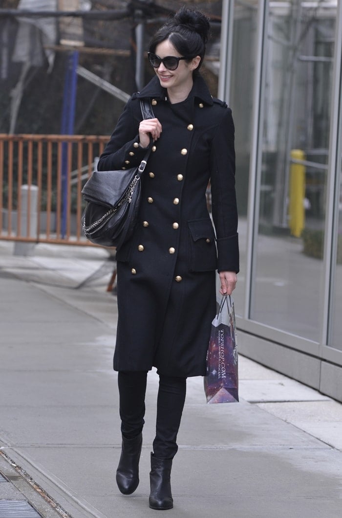 Krysten Ritter accessorized with huge sunglasses, leather boots, and a Jimmy Choo Biker handbag