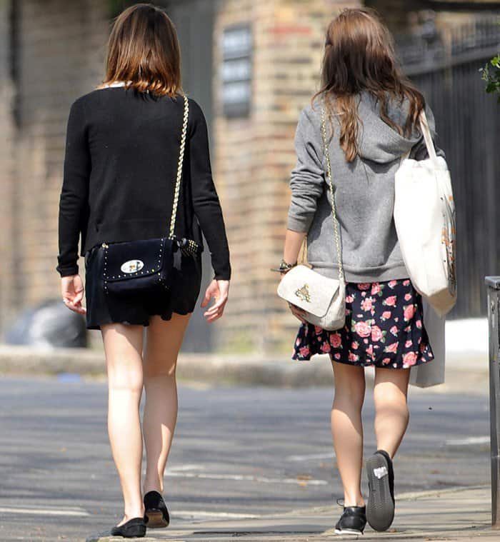 Emma Watson takes advantage of the spring sunshine in the U.K. and shows off her legs in black shorts as she and a friend stroll through West London