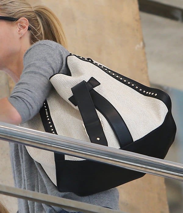 Gwyneth Paltrow totes a white Gucci soft stirrup straw shoulder bag