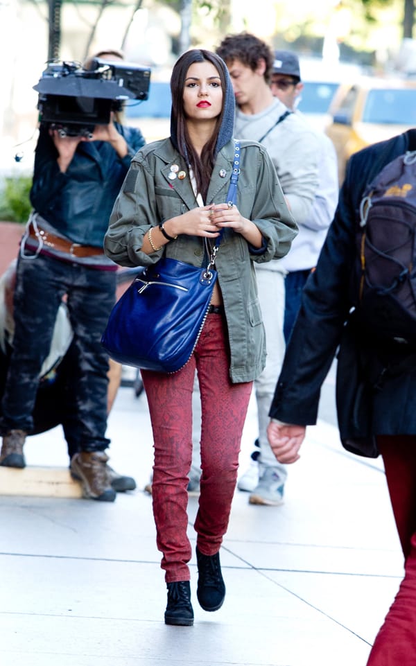 Victoria Justice sported a hooded military-style jacket paired with red snake print skinny jeans by Current/Elliott