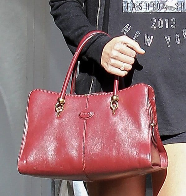 Taylor Swift carries a red tote handbag from Tod's Group