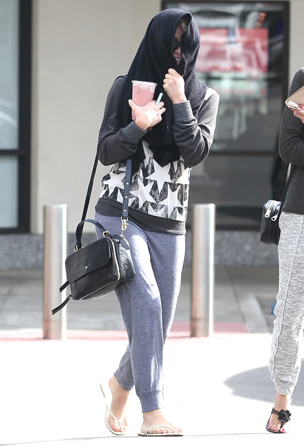 Julianne Hough hides her face with a scarf while showing off her Cynthia Vincent crossbody bag