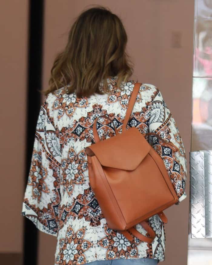Jessica Alba finished the look with a chic Loeffler Randall mini backpack in a beautiful Cuoio color that perfectly matched her whole ’70s-inspired ensemble