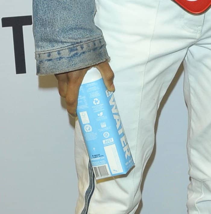 Jaden Smith carrying a Just Water box at the Louis Vuitton exhibition opening.