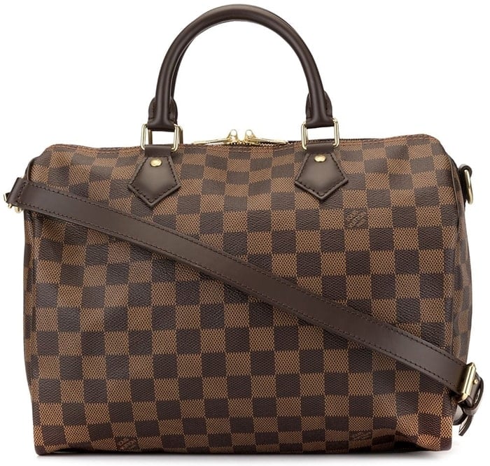 This brown leather Speedy holdall from Louis Vuitton features round top handles, a top zip closure, a detachable shoulder strap, a grid pattern, a printed logo, and an internal zipped pocket